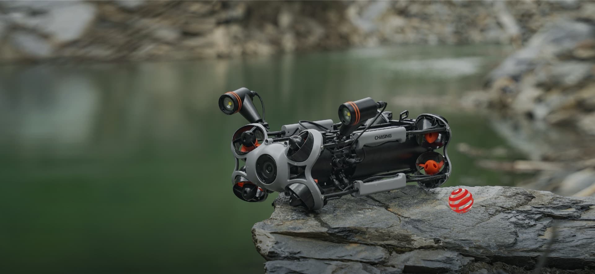 CHASING M2 PRO MAX na skalním výběžku nad zelenou vodou